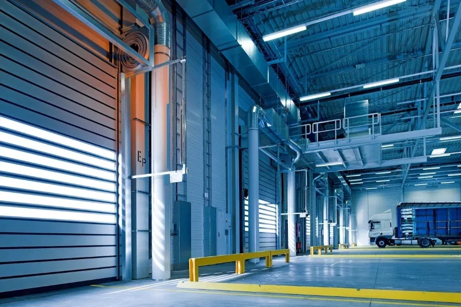 A mostly empty warehouse with a parked truck