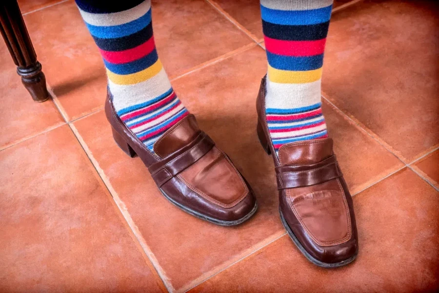 A person wearing vintage loafers and sporty socks