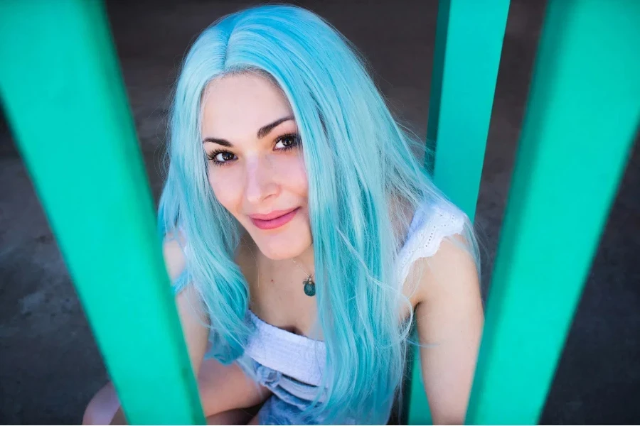 A smiling woman with a long blue wig