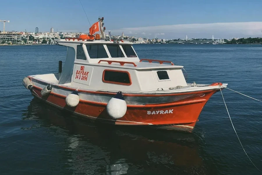 A white and orange yacht moored in a bay