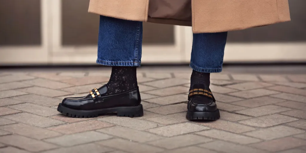 A woman wearing black socks with loafers