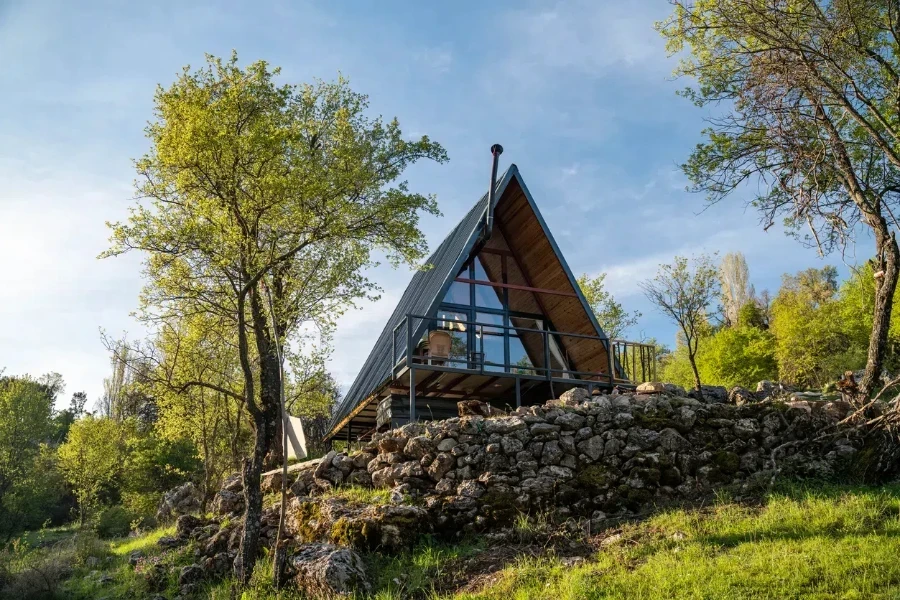 A wooden A-frame house nestled in natural surroundings