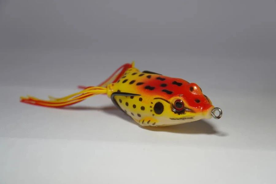 A yellow frog fishing lure on a gray background