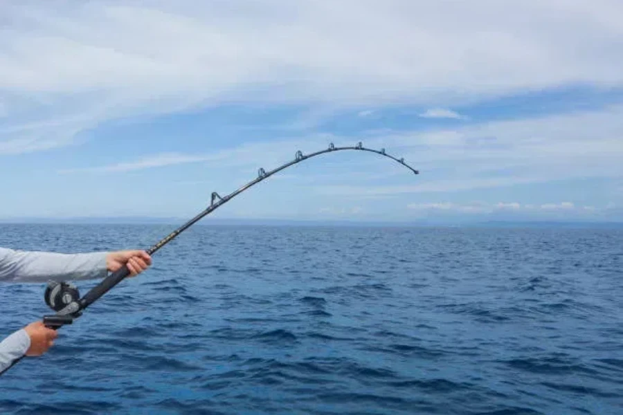 Un pescatore lancia il mulinello da pesca in acque libere durante il giorno