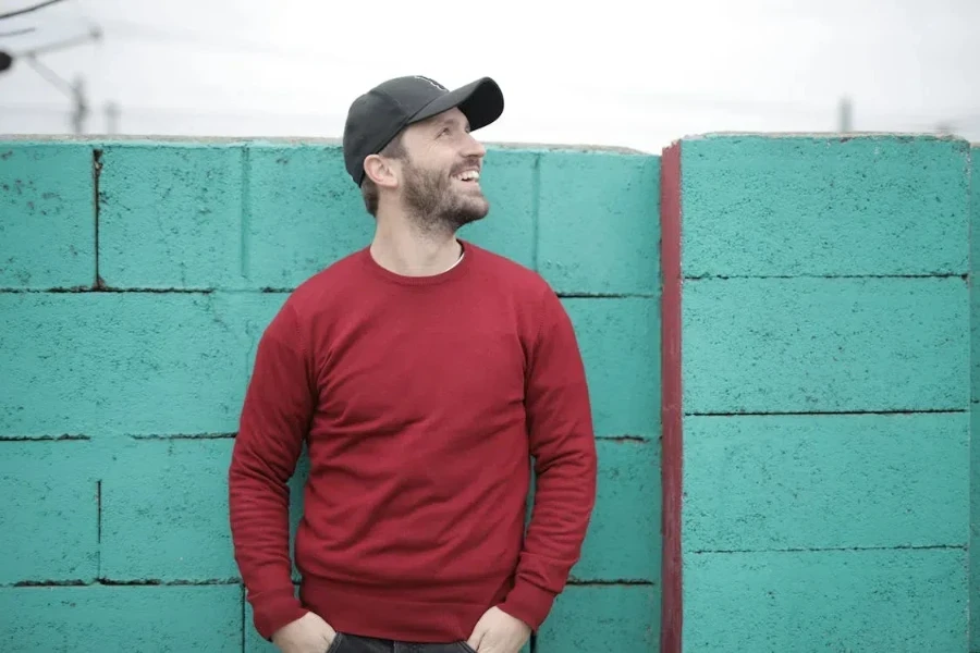 Cheerful man in a cap and reddish crewneck