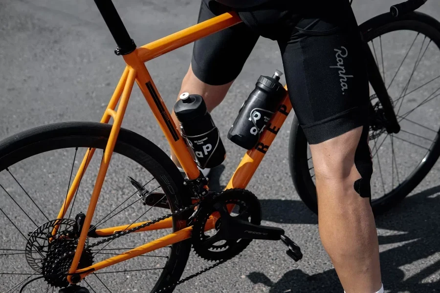 Cyclist on orange bike with perfect fit water bottles