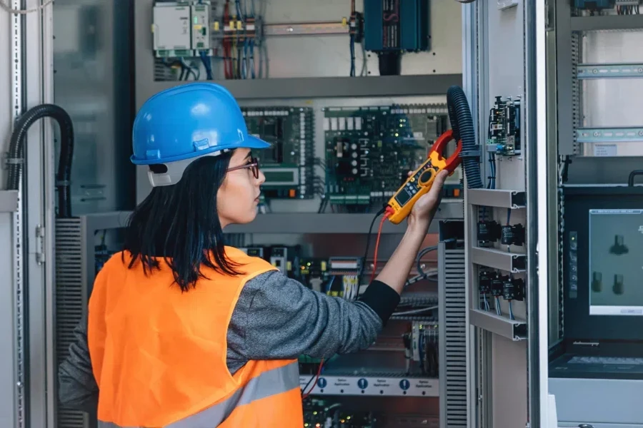 Female electrician checking electric voltage