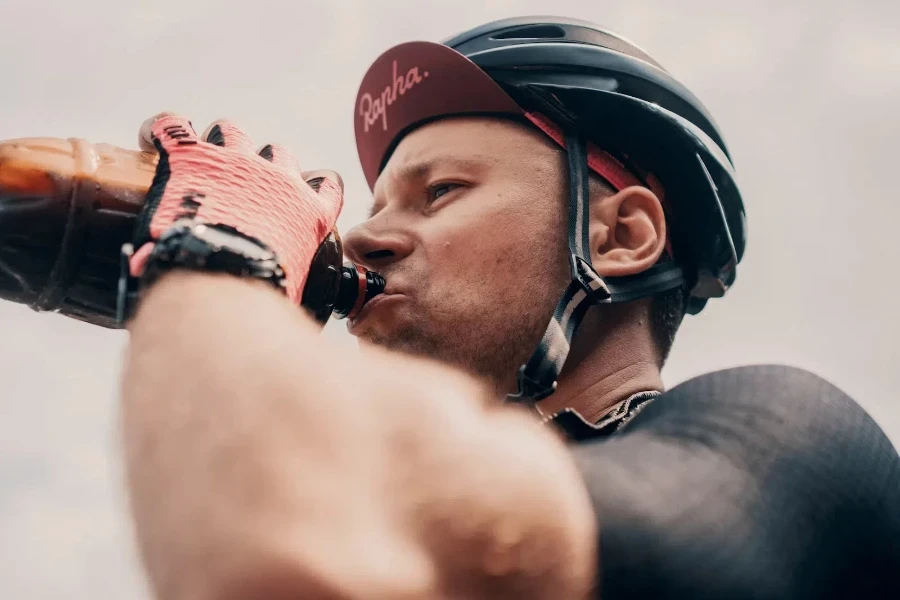 Male cyclist drinking from water bottle during journey