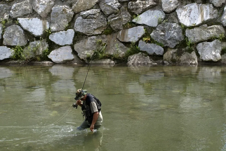 Man in murky water fishing with umbrella rigs