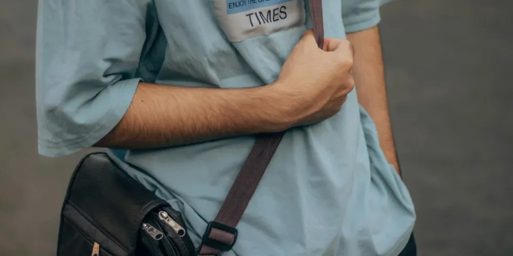 Man in oversized graphic tee and crossbody bag