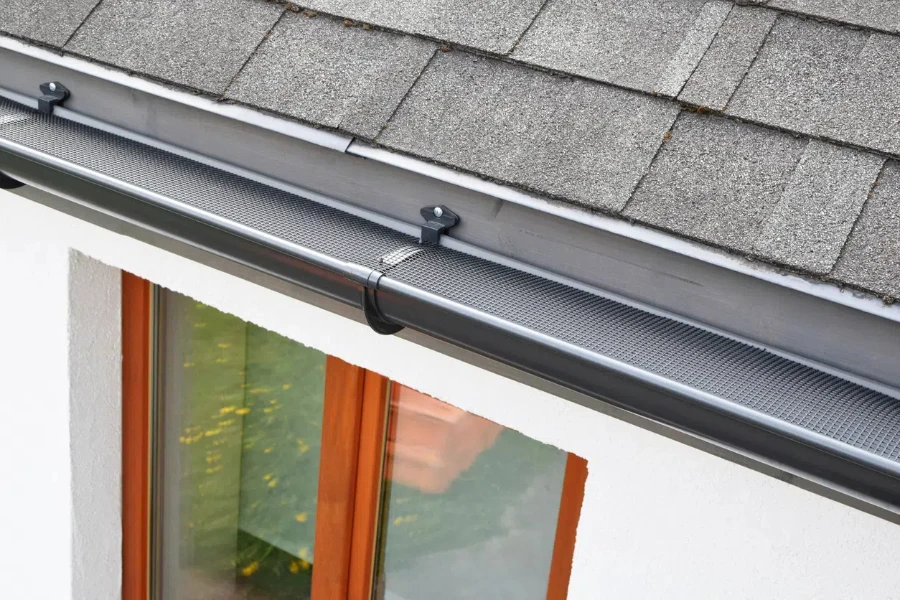 Plastic gutter guard over dark grey gutter