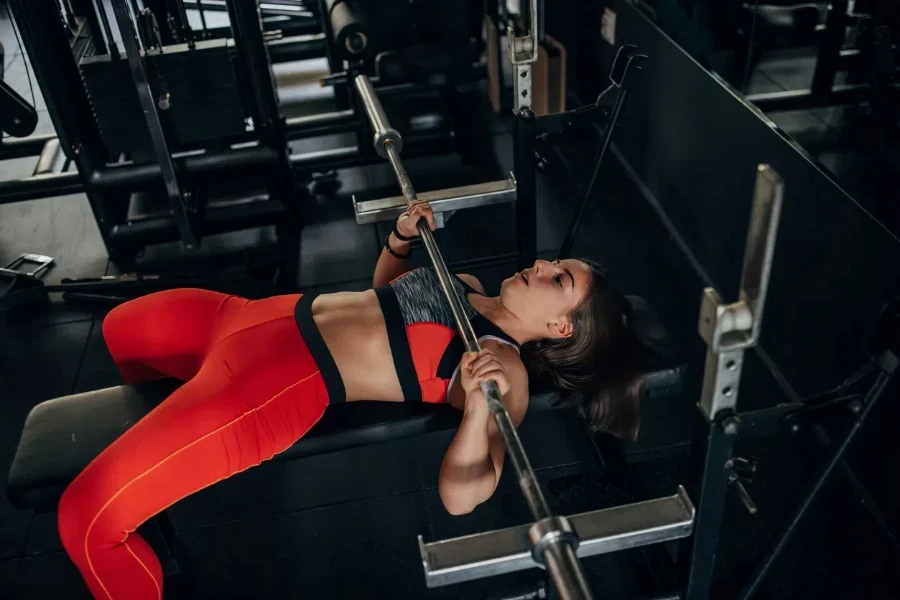 Sports woman lifting weight in a GYM