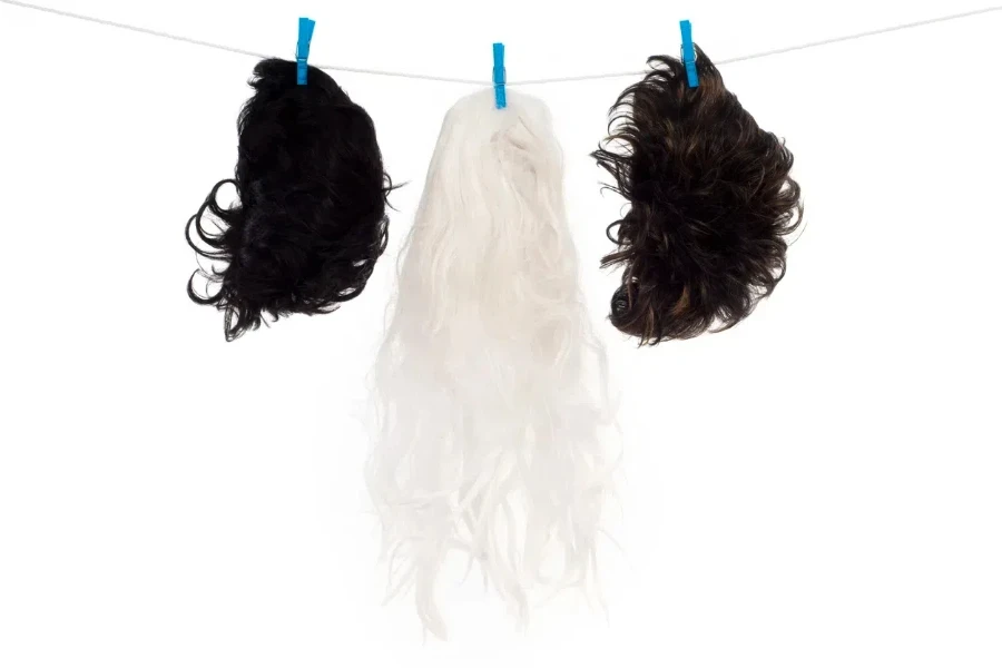 Three wigs hanging to dry side by side