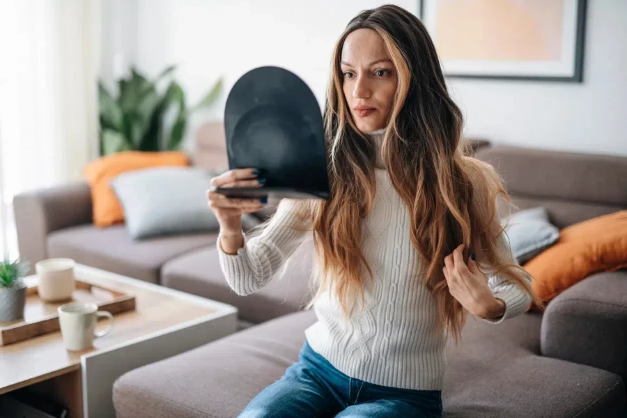 Woman adjusting her wig with a mirror