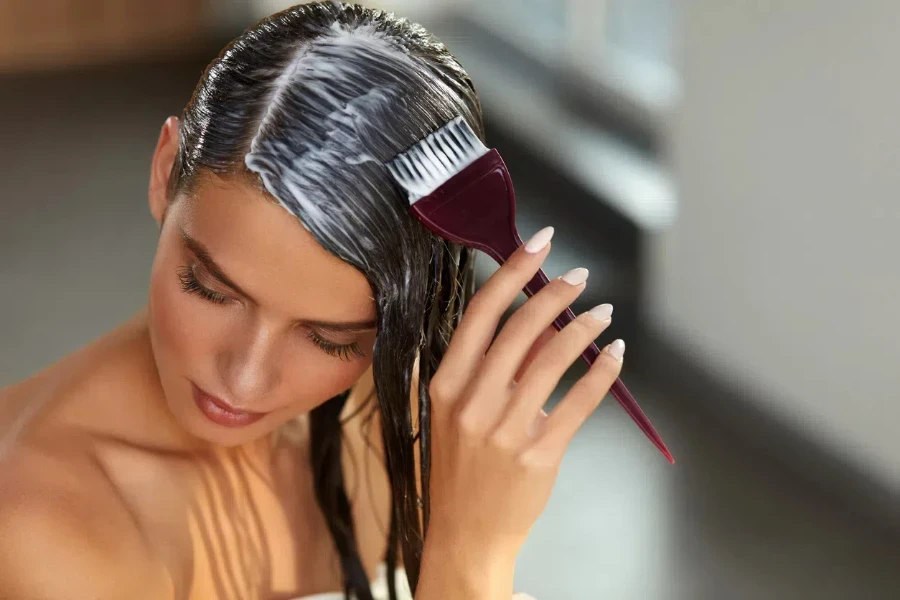 Woman applying mask on hair with a brush