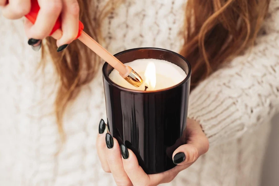 woman holding decorative candle lighting up candle