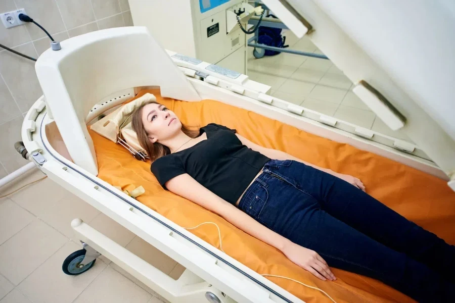 Woman in a hyperbaric therapy device with small chamber