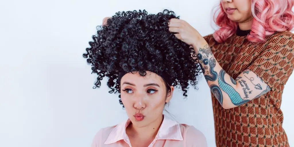 Woman placing a glueless wig on another lady