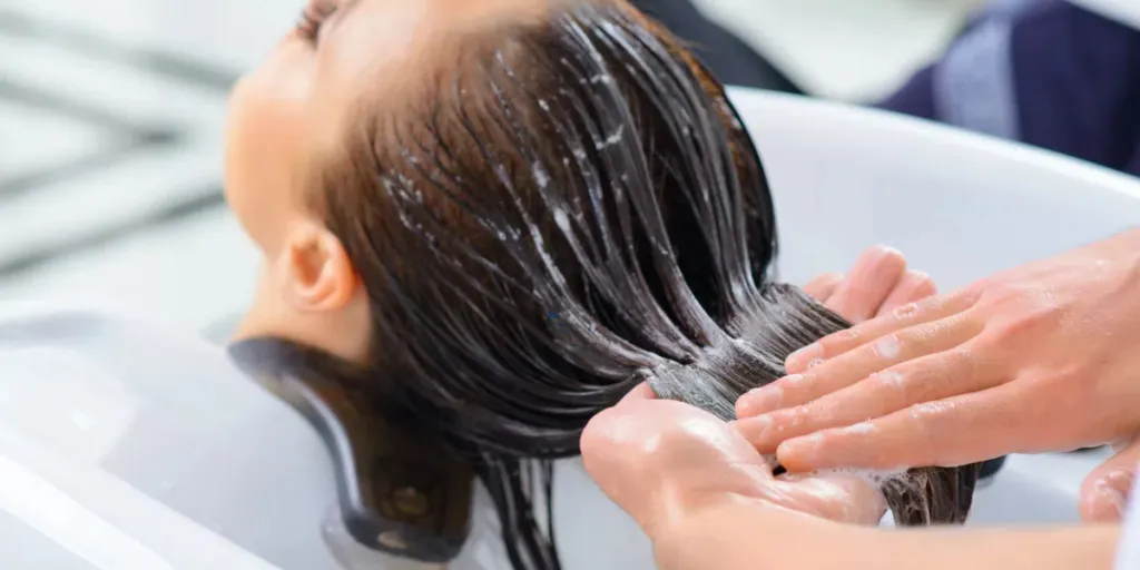 Woman reconditioning her hair at a saloon