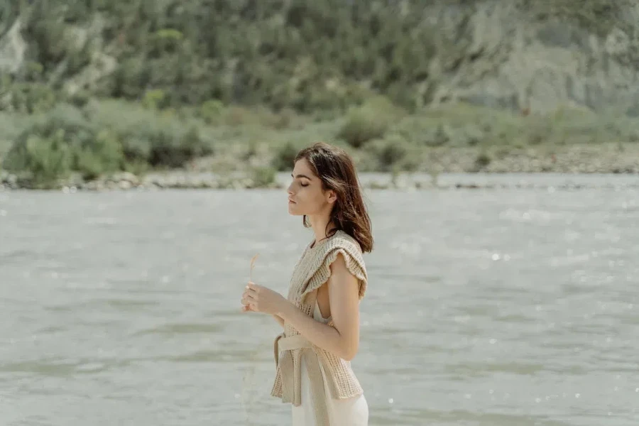 Woman with eyes closed wearing a peplum vest