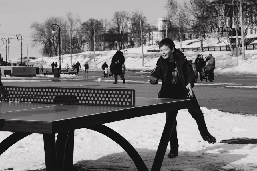 A boy playing table tennis on the snow