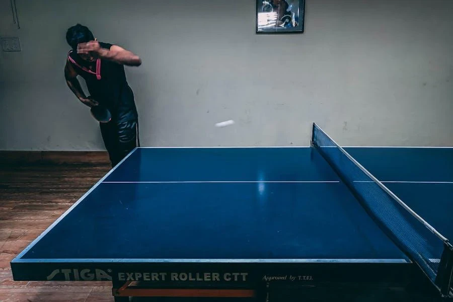 A man serving on a blue table tennis table