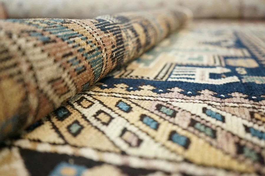 A multicolored rug being folded