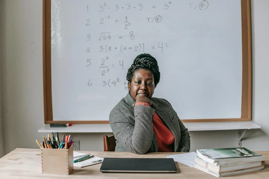 A person sitting at a desk with her hand on her chin