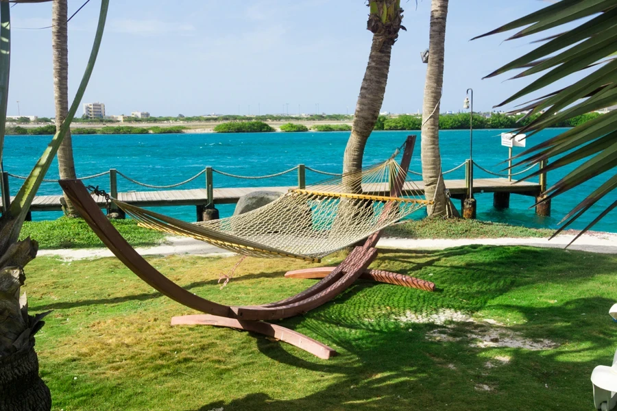 A rope hammock with a wooden stand