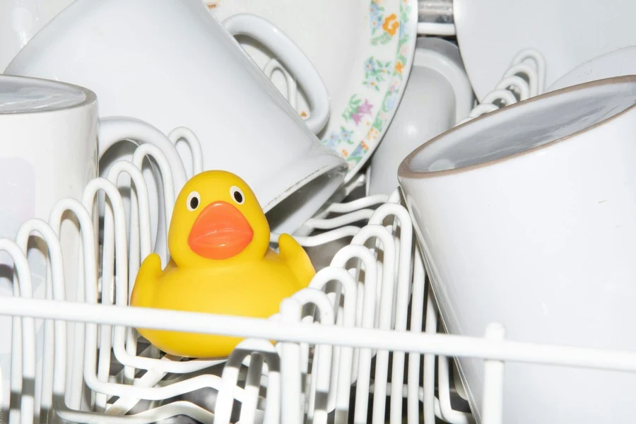 A yellow rubber duck sitting in a dishwasher