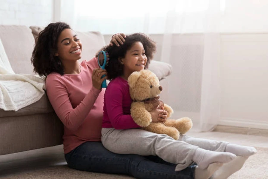 African Mom Combing Her Daughter's Hair