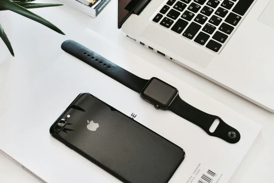 Apple Watch on a table beside iPhone and Macbook