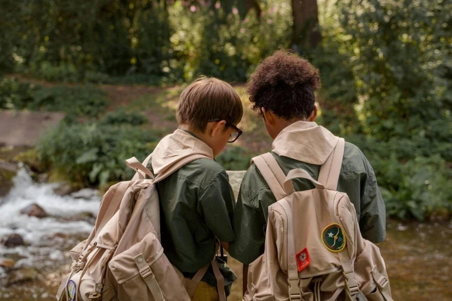 Back View of Two Boy Scouts Carrying a Backpack