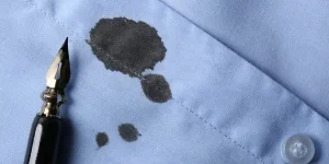 Noda tinta hitam pada kemeja dan pulpen biru muda