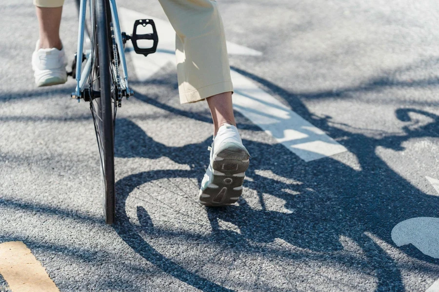 Crop person riding bicycle on street