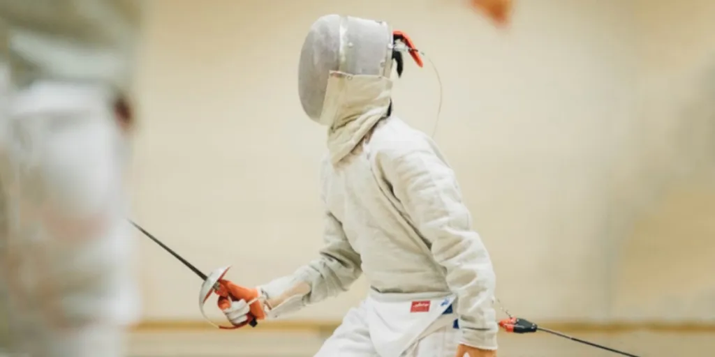 Fencer wearing fencing gloves and training equipment indoors