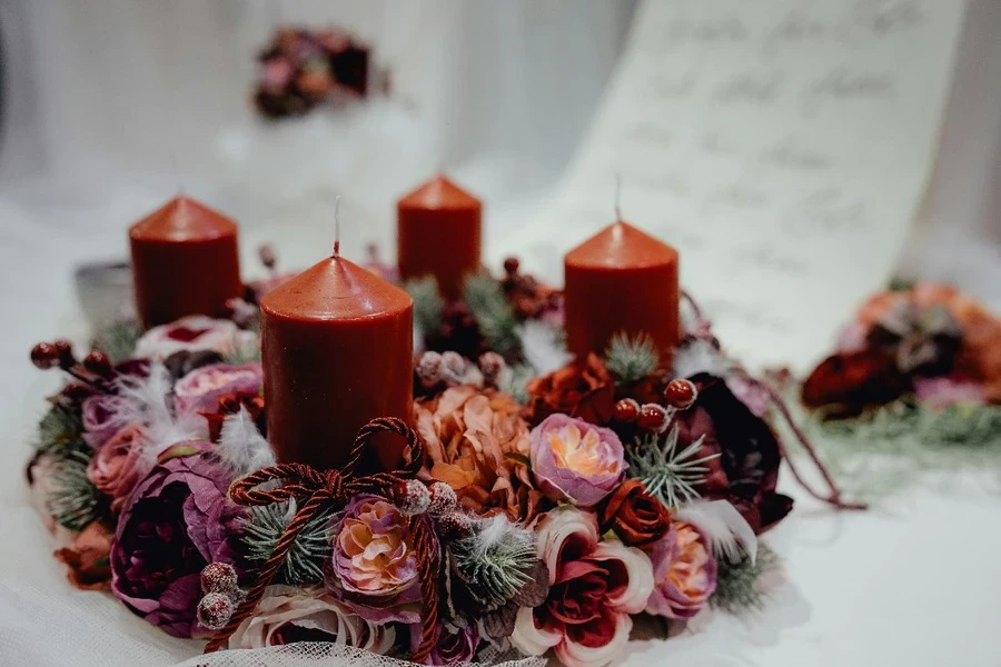 Four red candles surrounded by flowers