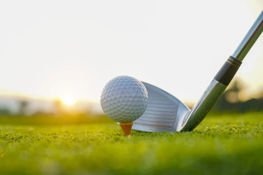 Golf clubs and golf balls on a green lawn in a beautiful golf course with morning sunshine