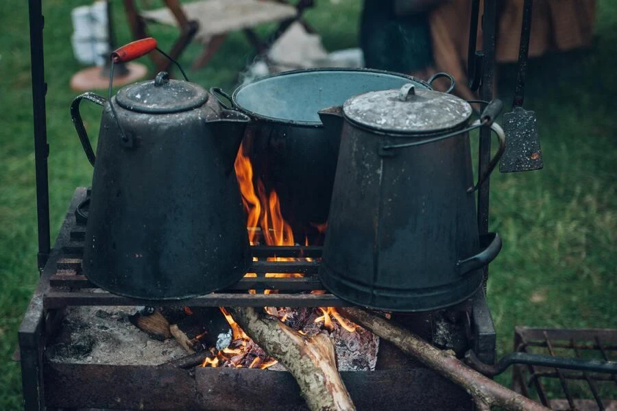 Kettles and pot on an open fire grill