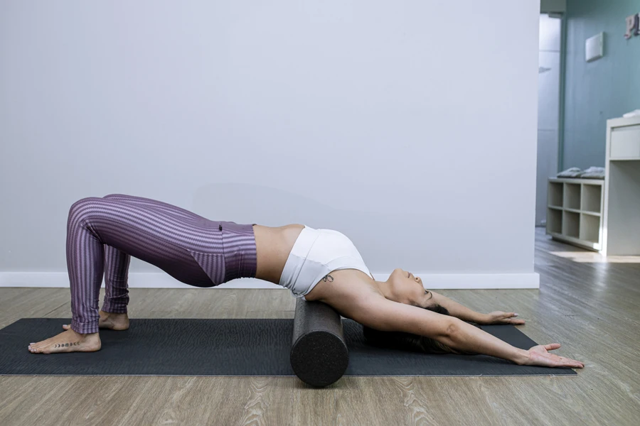 Lady using a foam roller during her pilate workout