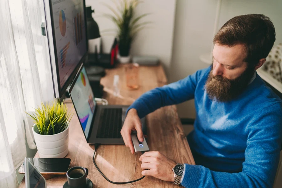 Man plugging an HDD enclosure to his laptop