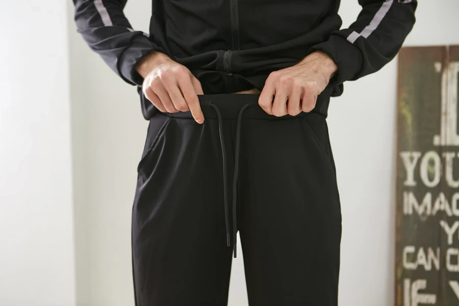 Man showcasing black tailored sweatpants