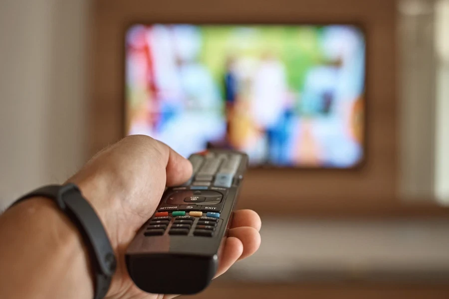 Man switching channels using remote control