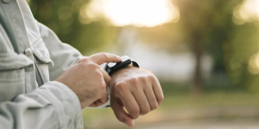 Man's hand touching a smartwatch