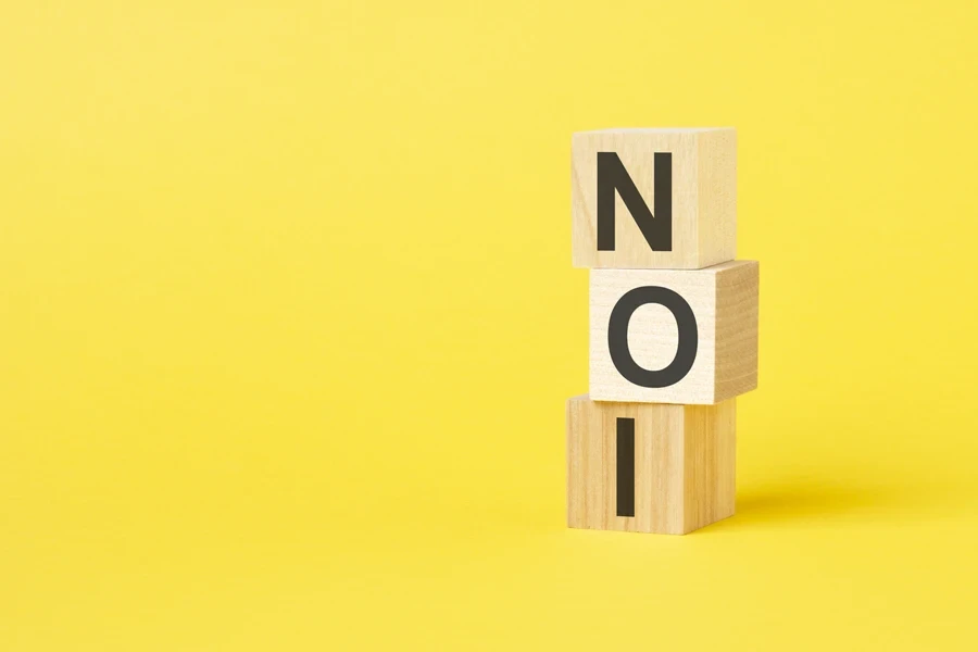 NOI on wooden cubes on a yellow background