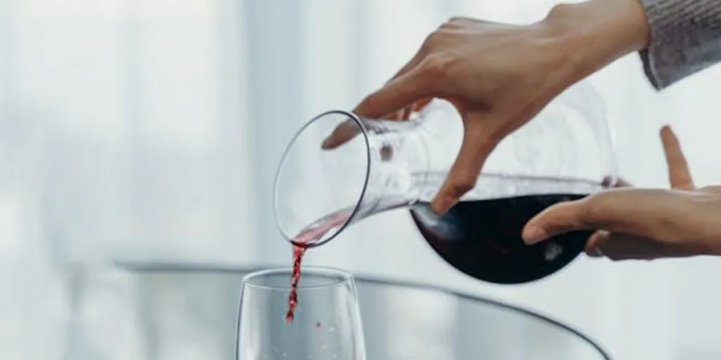 Person pouring wine from a wine decanter