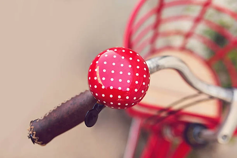 Red and white polka dot bicycle bell on handlebar