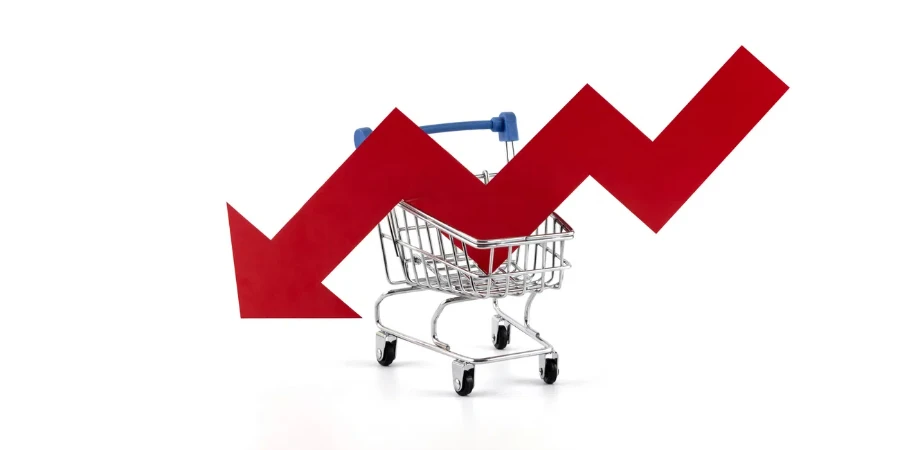 Red arrow financial graph falling in supermarket shopping cart on white background