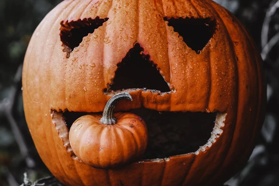 Small pumpkin in the mouth of a large pumpkin carving