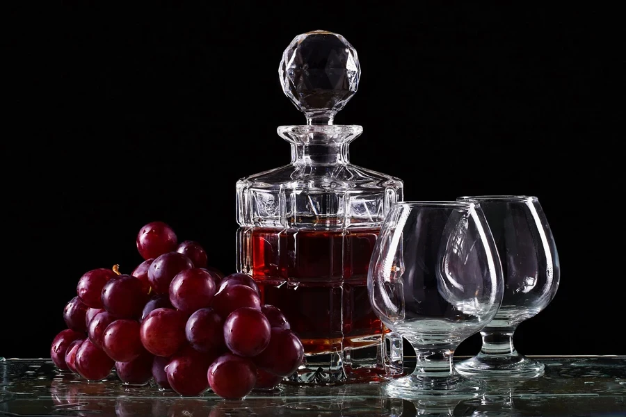 Small wine decanter with two glasses and grapes